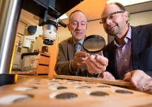 Associate Professor Kenneth Sheedy and Dr Gil Davis examine ancient coins.