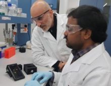 Researchers Anwar Sunna (right) and Vinoth Kumar Rajendran with their smartphone-enabled MRSA detector. Credit: Sunna Lab