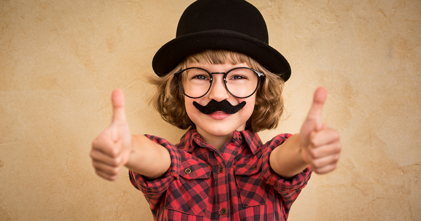 Funny kid with fake mustache. Happy child playing in home