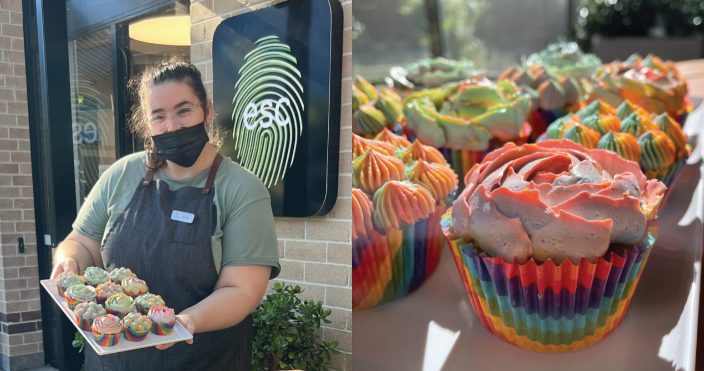 Person holding rainbow cupcakes